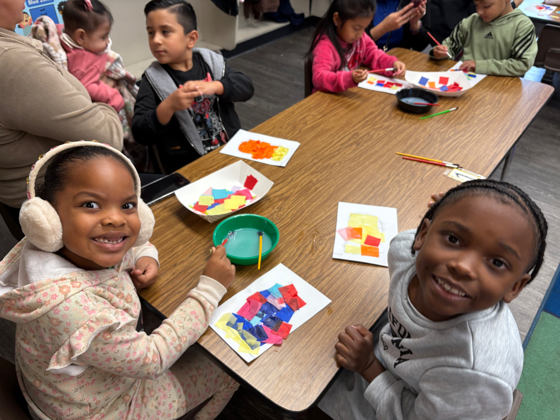 Children smiling with tissue paper collages